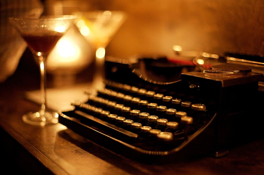 bokeh shot, black, typewriter, keyboard, table, display, lamp, light, wine, glass