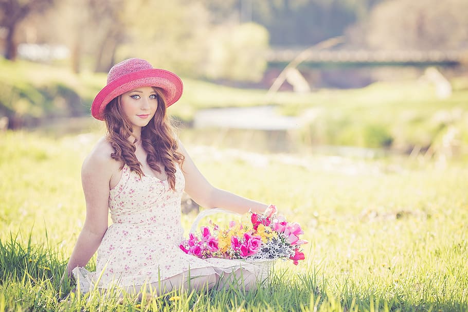 woman, sitting, ground, holding, bouquet, basket flower, flowers, spring, pink, hat