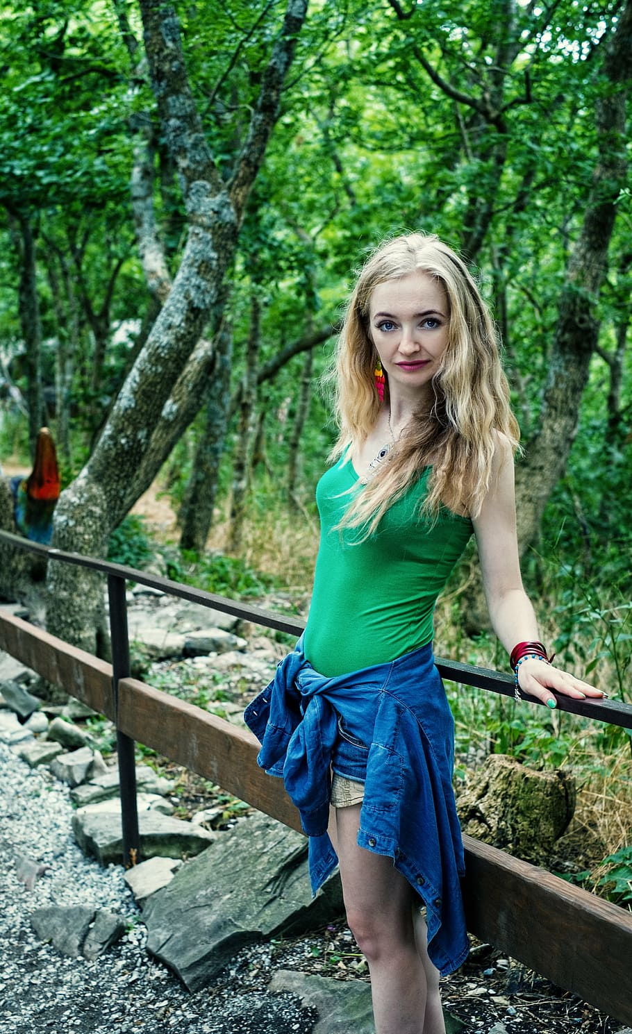 woman, wearing, green, camisole, standing, behind, railing, across, trees, girl