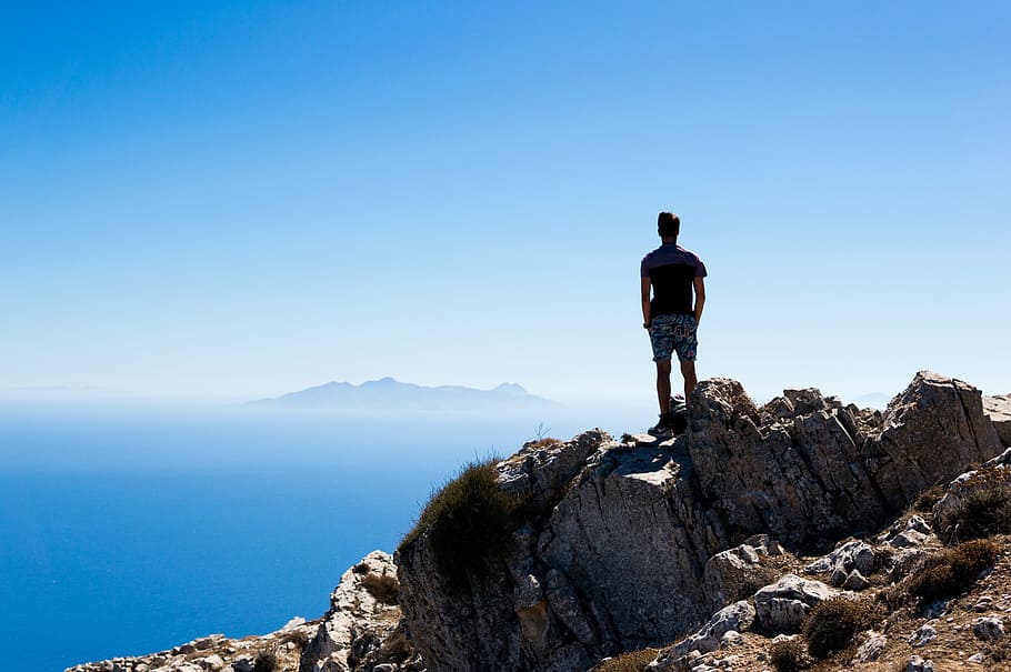 man, standing, rock, overlooking, island, straight, mountain, peak, near, sea