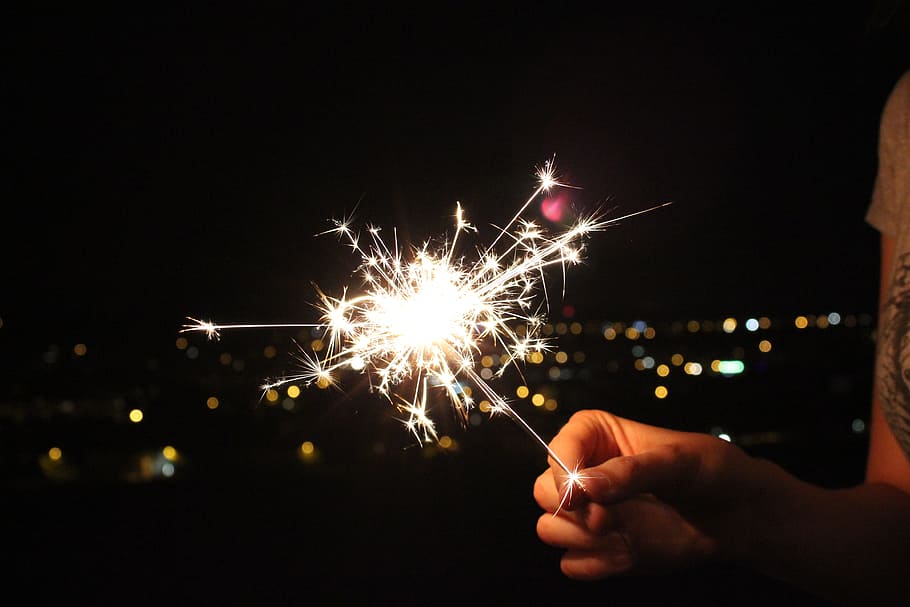 person holding sparkler, sparkler, night, radio, spray, light, illuminated, firework, holding, hand