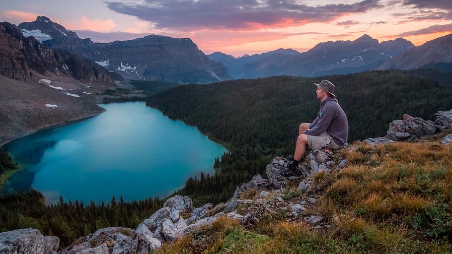 man, sitting, rocky, hillside, watching, lake, mountain, daytime, person, gray