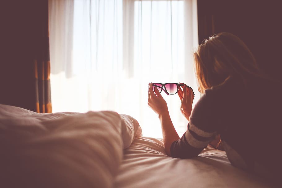 woman, holding, black, sunglasses, inside, bedroom, lady, pillow, sheets, female