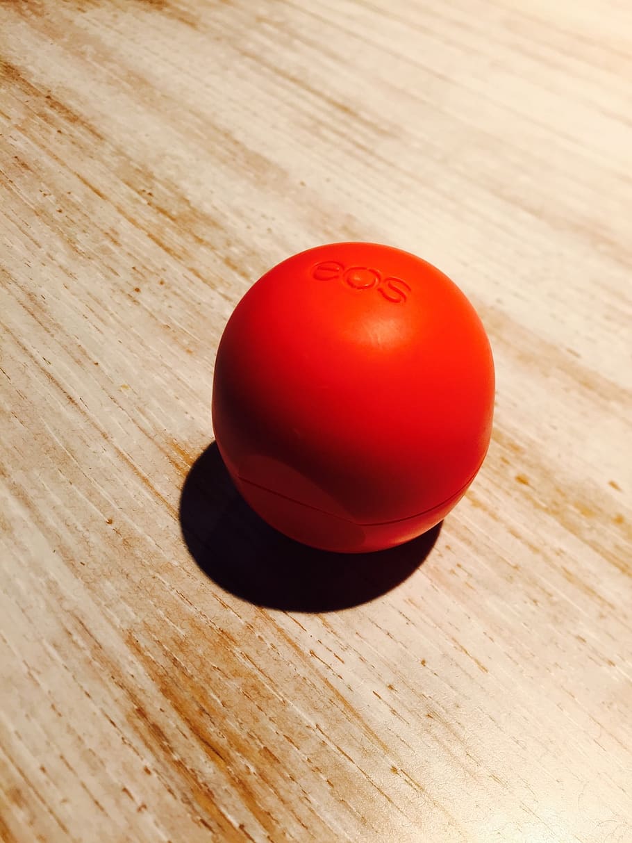 eos, lip balm, red, table, wood - material, still life, indoors, high angle view, single object, tomato