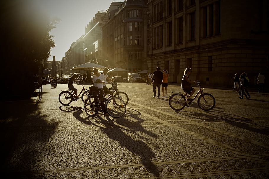 group, person, riding, bicycles, silhouette, people, near, concrete, building, bikes