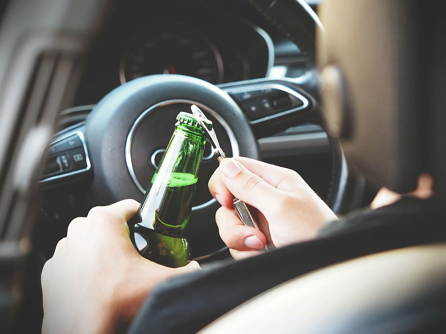 person opening glass bottle, inside, vehicle, alcohol, automotive, beer, bottle, opener, bottle opener, car