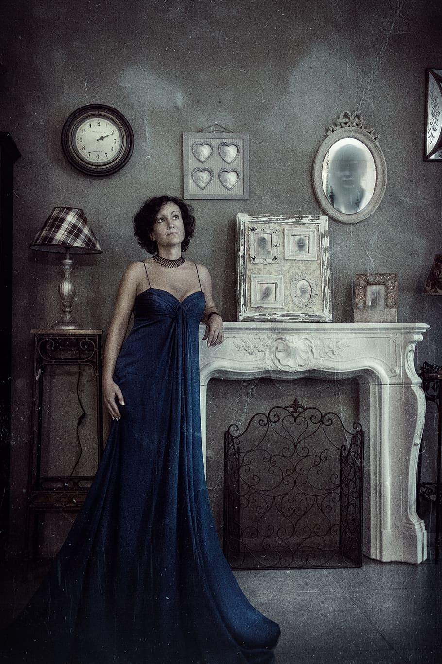 woman, blue, dress, leaning, white, concrete, fireplace mantel, staring, woman in blue, blue dress