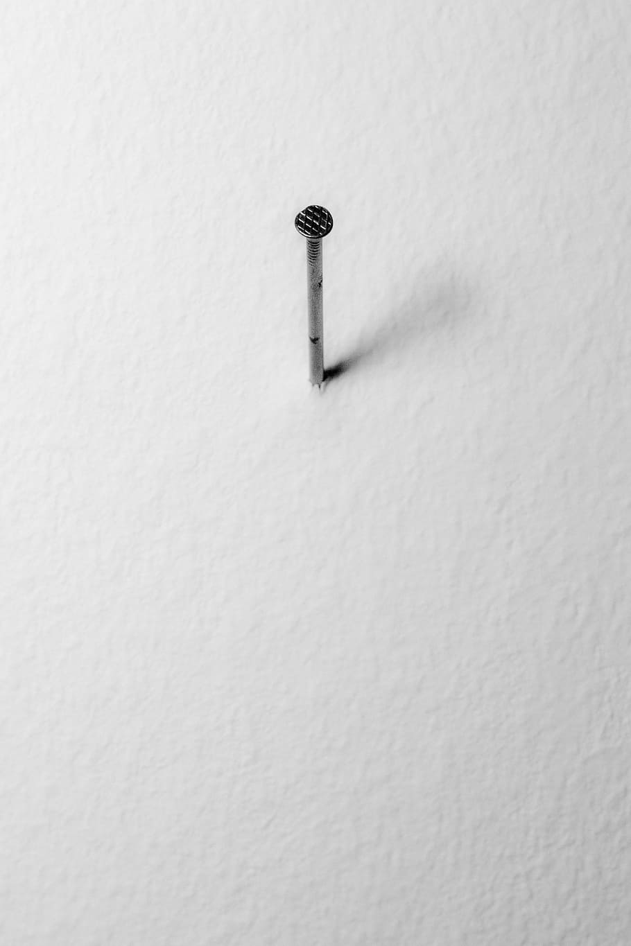 background, still life, black and white photography, simplicity, wall, nail, stability, white color, close-up, wall - building feature