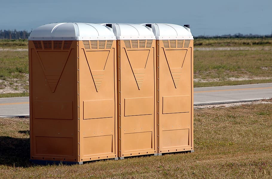 three brown containers, portable toilets, outdoors, events, portable, toilet, public, plastic, lavatory, restroom