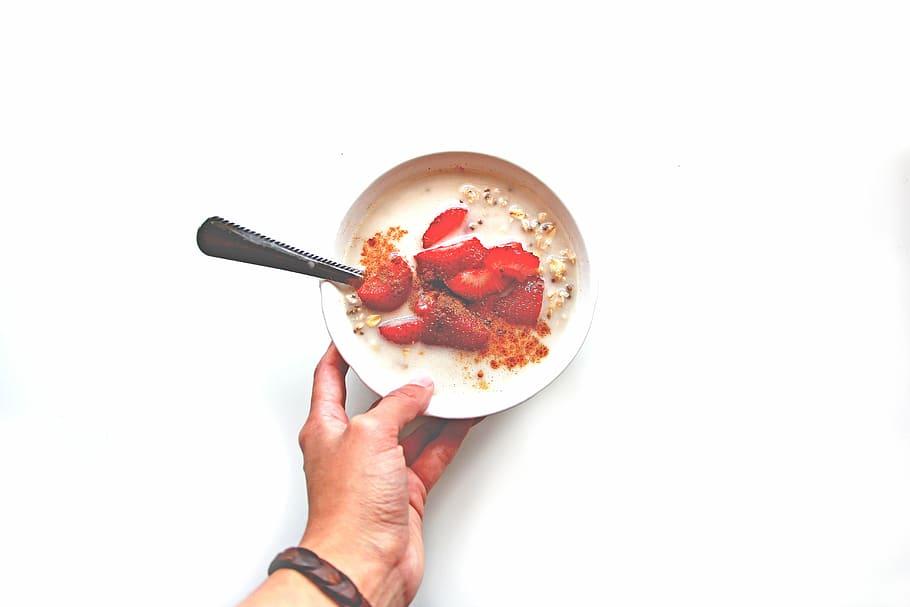 person, holding, bowl, dessert, sliced, strawberry, white, ceramic, oatmeal, strawberries