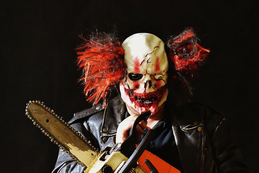 person, halloween costume, holding, orange, gray, white, chainsaw, horror clown, mass murderer, mask