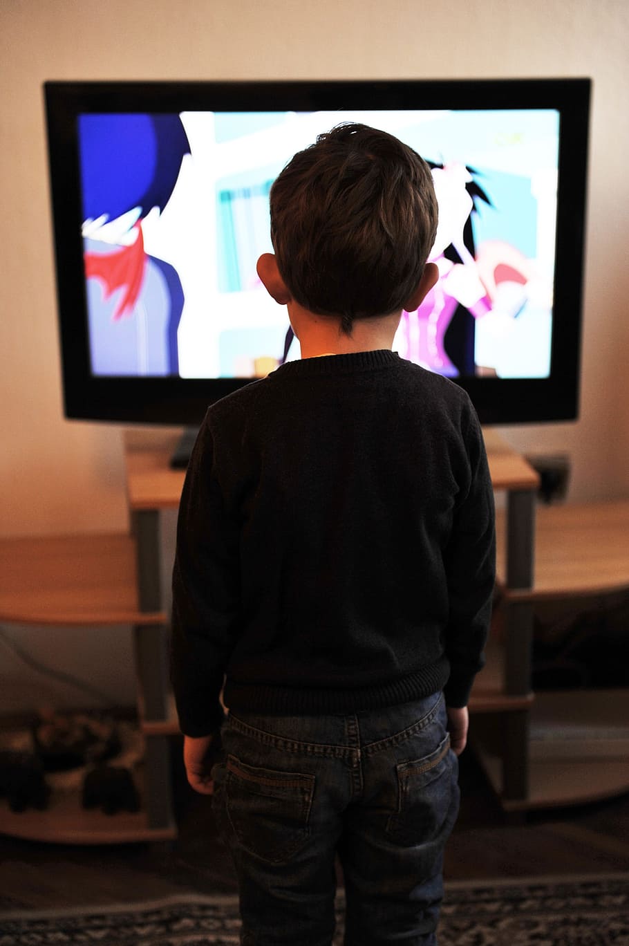 kid, black, crew-neck sweater, standing, front, flat, screen television, children, tv, child