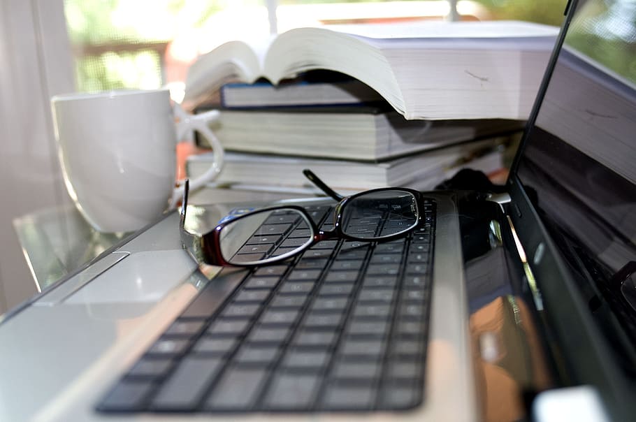 eyeglasses, pc, computer, apple, screen, cup of coffee, sunglasses, stack of books, desktop computer, business