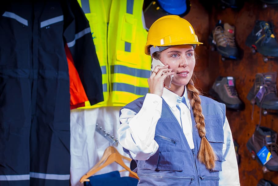 woman, white, button, shirt, holding, smartphone, woman in white, button up, helmet, industrial