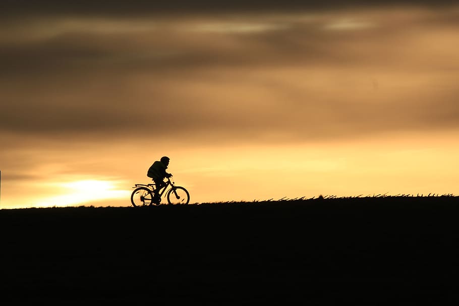 cyclists, silhouette, sunset, evening sky, hilly, sunlight, sky, bicycle, activity, one person