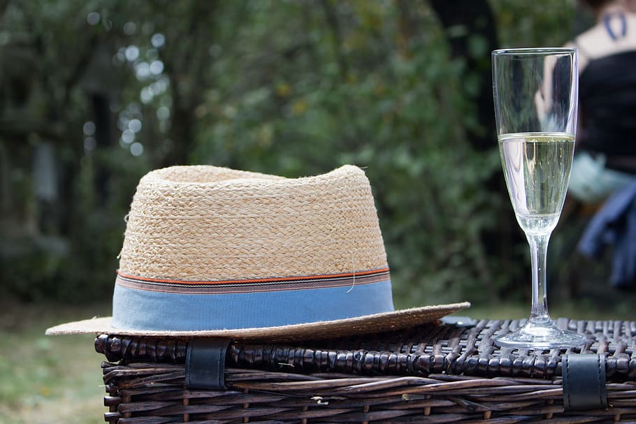seletiva, fotografia de foco, chapéu fedora, ao lado, flauta de champagne, cesta de vime, piquenique, chapéus, champanhe, ao ar livre