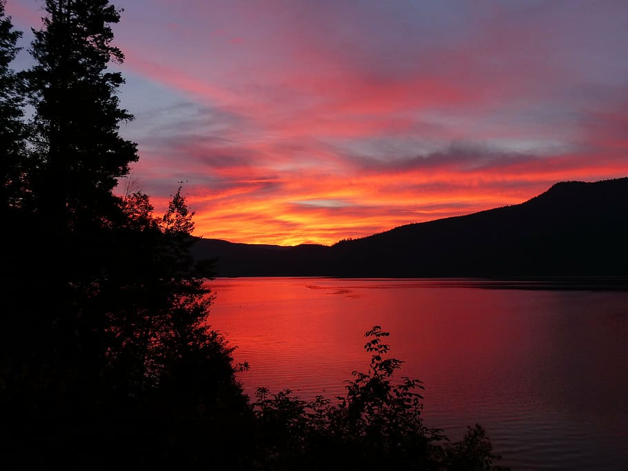 photo of silhouette, glowing, sun rise, canim lake, british columbia, canada, lake, water, hills, mountains