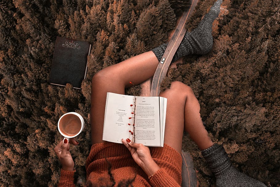 woman, wearing, orange, sweater, grey, socks reading, book, white, mug, relax