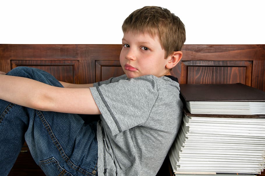 boy, wearing, gray, crew-neck t-shirt, leaning, book lot, sad, learning, school, reading