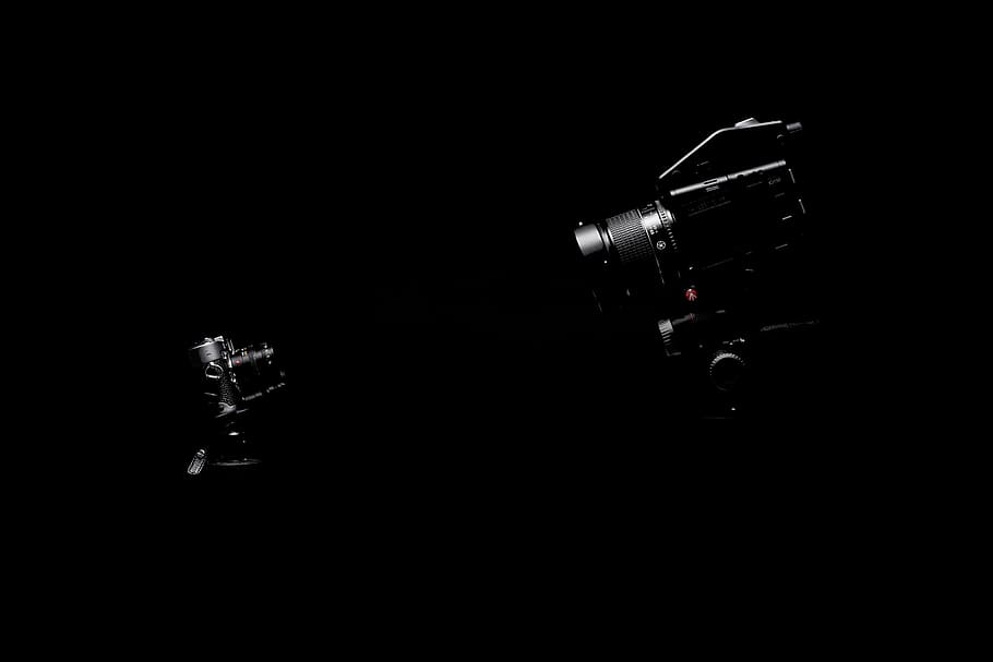 two cameras facing, camera, digital, videography, photography, black, technology, studio shot, black background, indoors