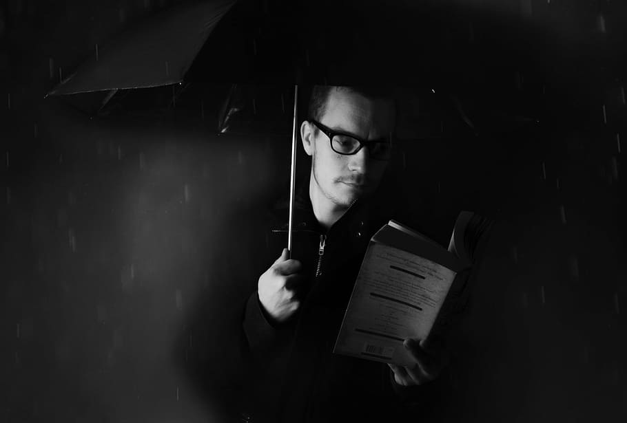grayscale photograph, man reading book, umbrella, rain, man, people, book weather, night, dark, wet