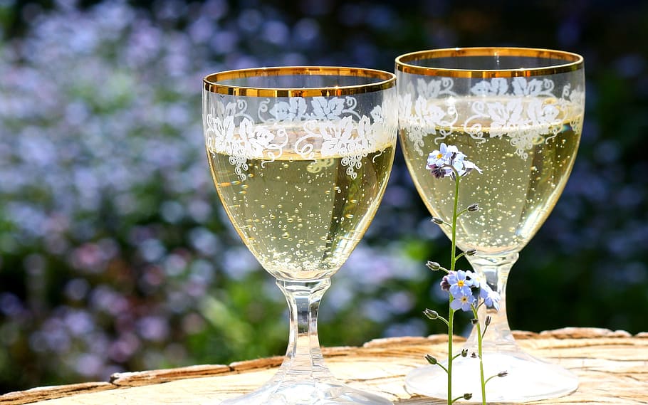 two, clear, footed glasses, filled, liquid, champagne, glasses, abut, spring, flowers