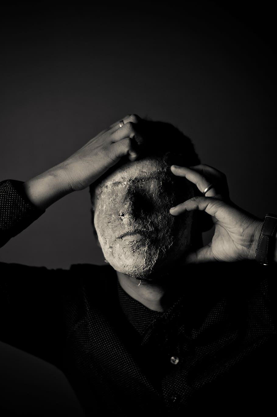 grayscale photography, man, holding, face, covered, mud, dark, black, white, people