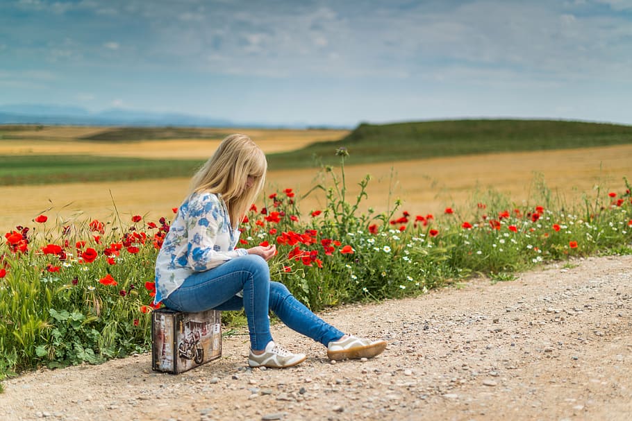 girl, wearing, blue, white, floral, long-sleeved, shirt, fitted, jeans, sitting