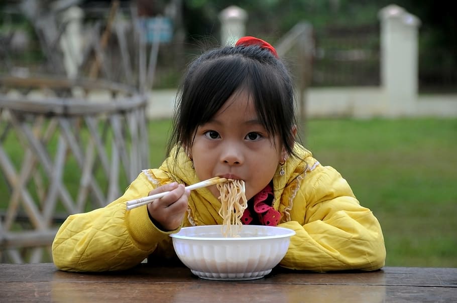 girl, yellow, hoodie eatting noodles, table, child, noodle, high land, family pass north, vietnam, breakfast