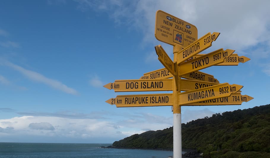 Surtido, señalización amarillo y negro, azul, cielo, Bluff, Isla Sur, Nueva Zelanda, Señales, señales amarillas, señales de distancia