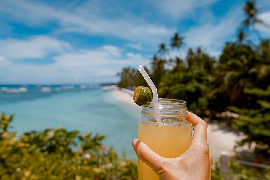 person, holding, lemon juice jar, sea, beach, white, sand, sunny, day, sun