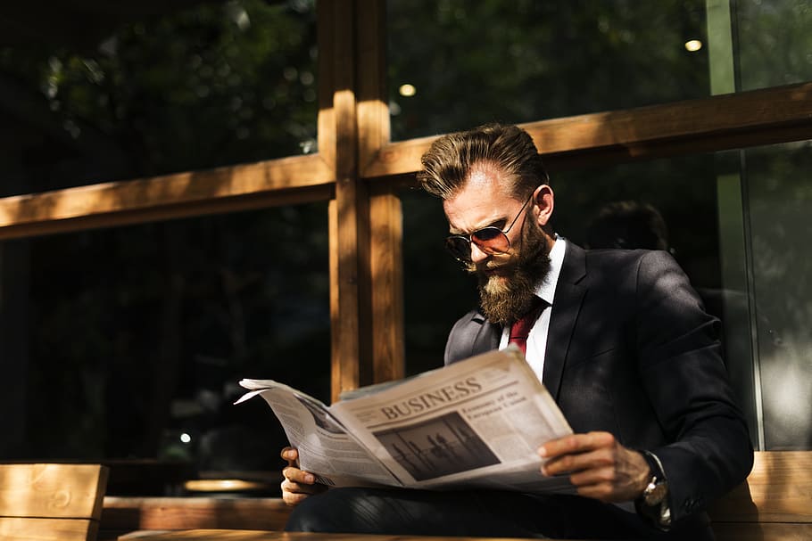 man, wearing, black, white, tuxedo suit reading newspaper, daytime, beard, break, business, businessman
