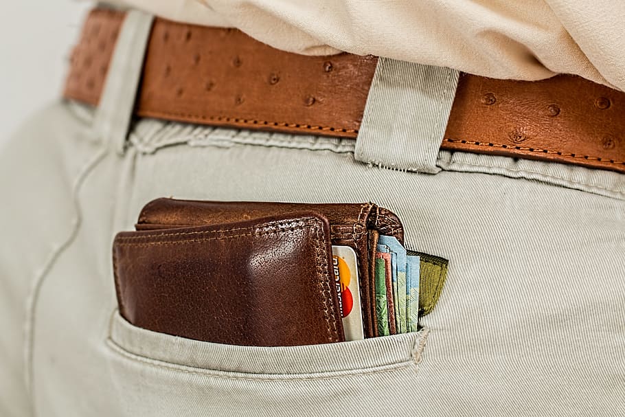 person, wearing, gray, denim bottoms, brown, leather wallet, wallet, cash, credit card, pocket
