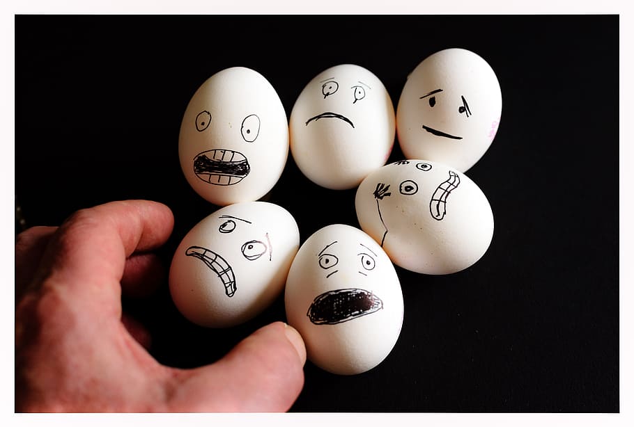 person, holding, several, face-printed poultry eggs, scared eggs, egg, food, nutrition, eat, chicken eggs