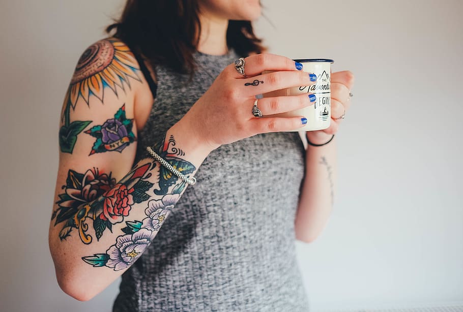 mujer, de pie, sosteniendo, blanco, jarra, tatuajes, brazo, piel, tatuajes de flores, manos