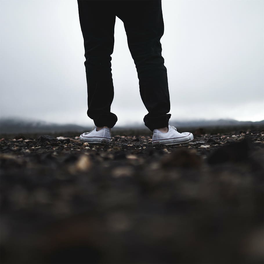 shallow, focus photograph, person, wearing, black, pants, white, sneakers, pair, converse