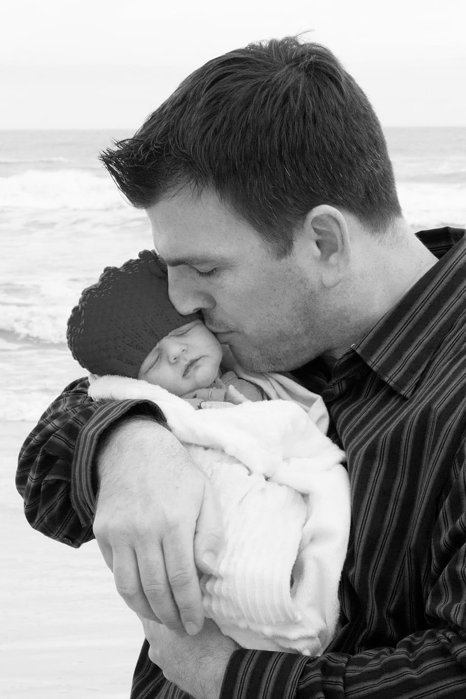 foto en escala de grises, hombre, besos, bebé, envuelto, toalla, orilla del mar, papá, recién nacido, océano