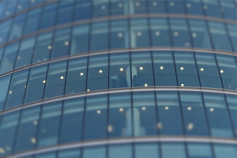 fotografía de ángulo bajo, edificio de pared de vidrio, persona, de pie, detrás, azul, gris, edificio, ventanas, arquitectura