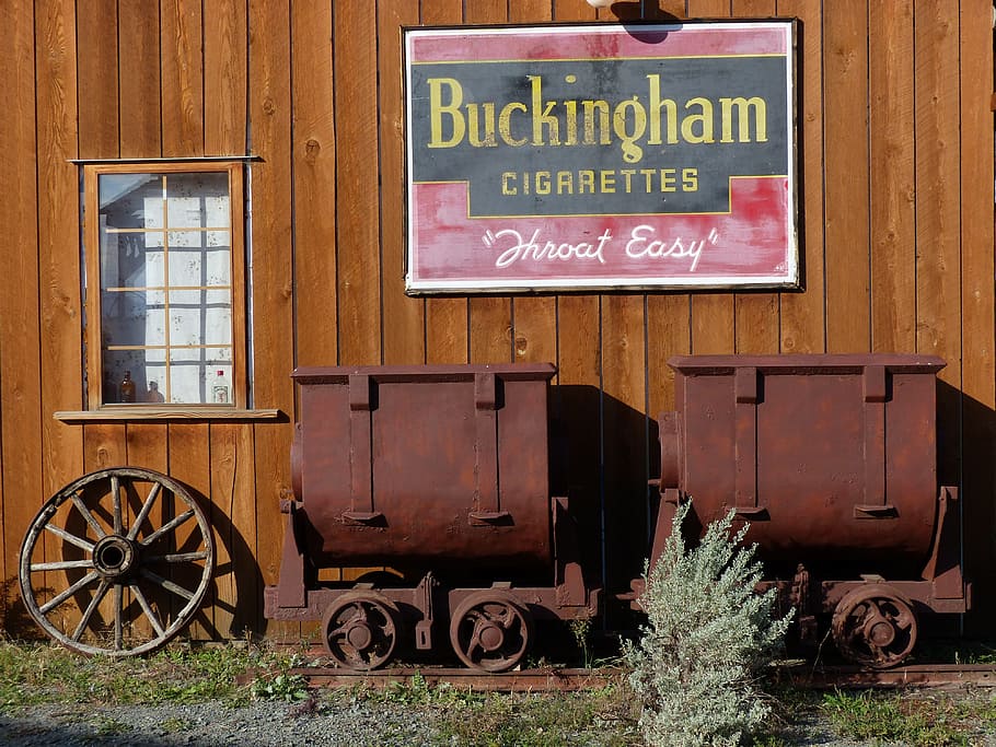 signo de cigarrillos de buckingham, marrón, tren, estacionado, al lado, pared, durante el día, rancho de muertos, antiguo, edificios