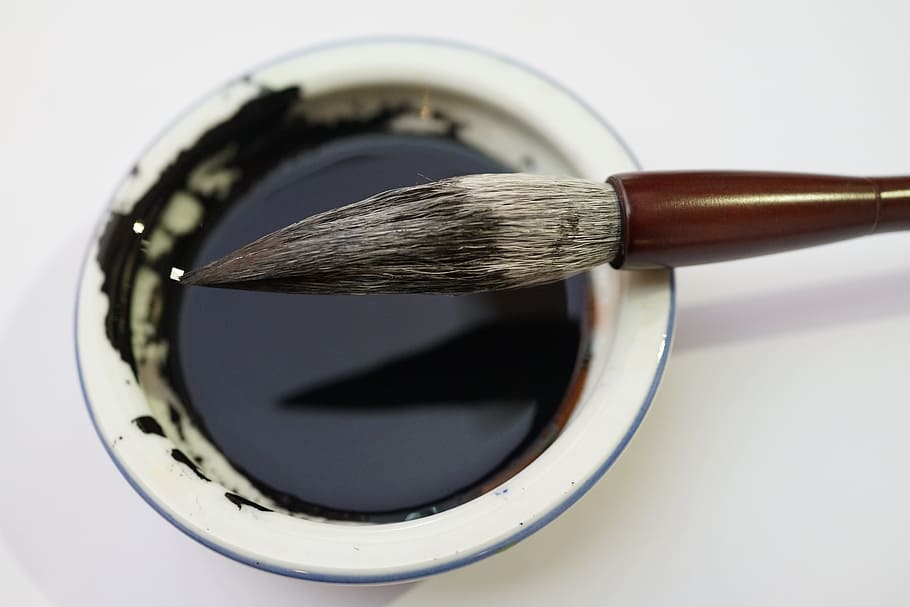 brown paintbrush, calligraphy brush, ink well, chinese calligraphy, aesthetically, artistic expression, highly esteemed, chinese cultural sphere, studio shot, close-up