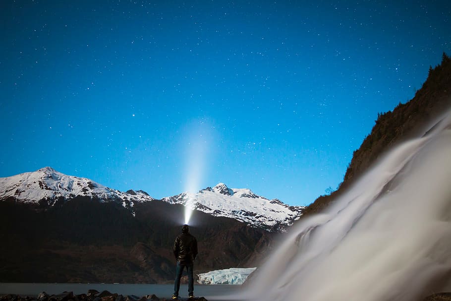 person, holding, lighted, flashlight, mountain, highland, sky, hill, cliff, waterfalls