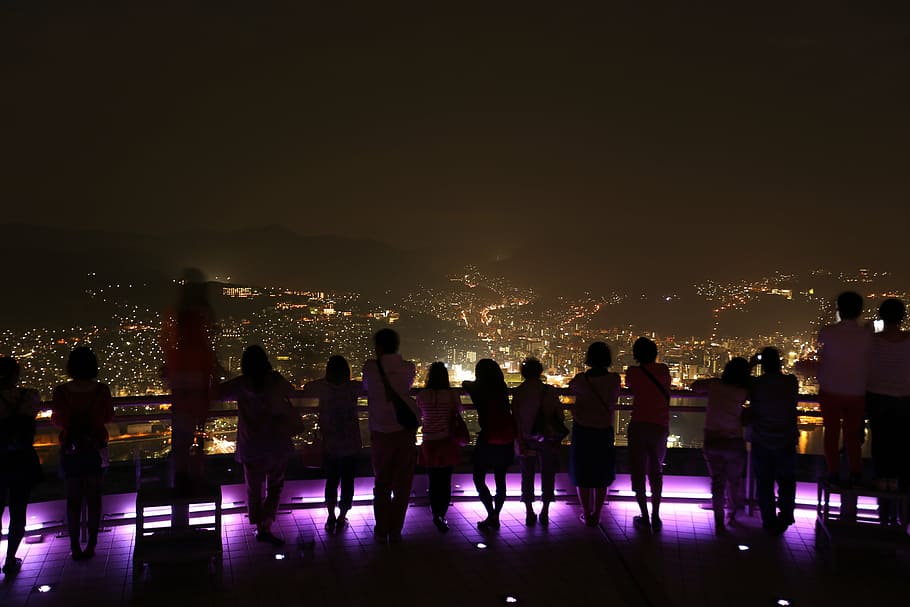 people, standing, leaning, railing, overlooking, city, lights, nighttime, man, woman