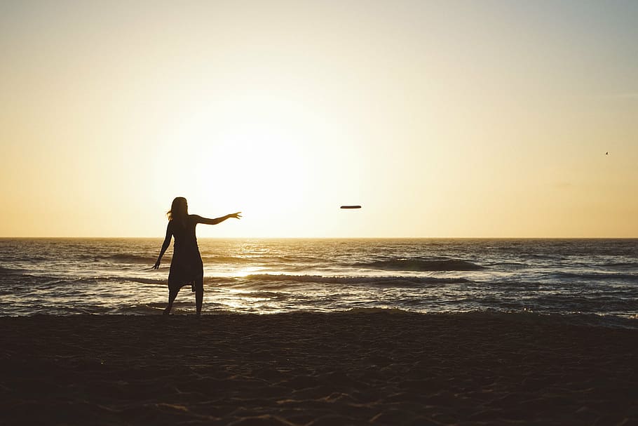 silhueta, mulher, jogando, disco frisbee, praia, foto, frisbee, beira-mar, crepúsculo, céu