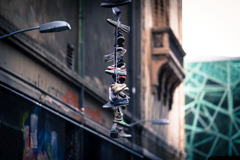 shoes, skewered. stacked, building, lamp, posts, architecture, building exterior, focus on foreground, hanging, built structure