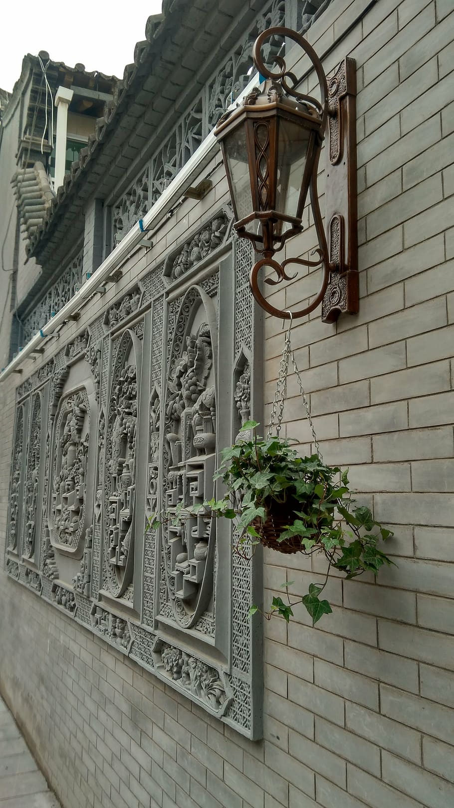 ancient architecture, wall sconce, brick wall, green plants, building exterior, architecture, built structure, low angle view, building, day