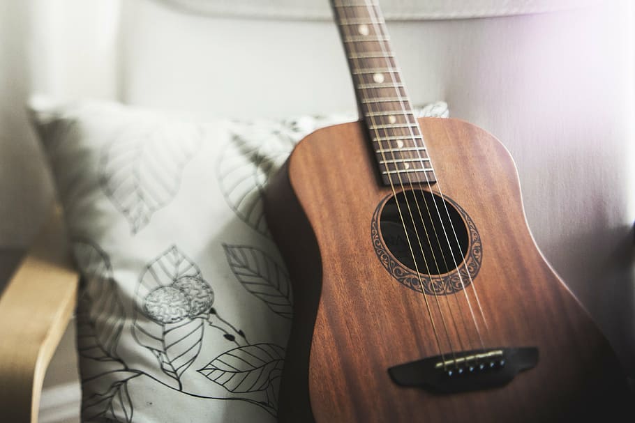 selective, focus photo, brown, acoustic, guitar, leaning, white, black, floral, throw