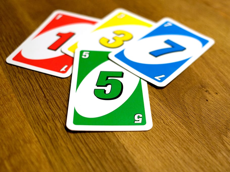 un, card game, cards, socializing, color, wooden table, wood - material, indoors, communication, number