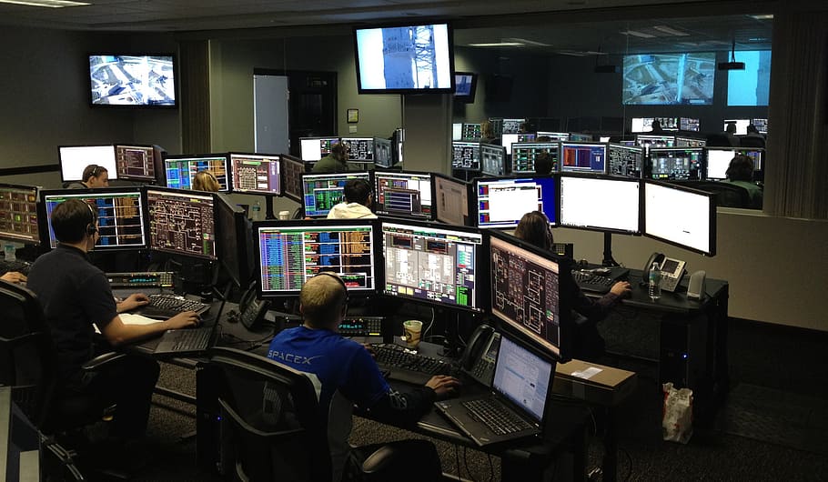 person, wearing, blue, long-sleeved, shirt, using, desktop computer, set, space center, spacex
