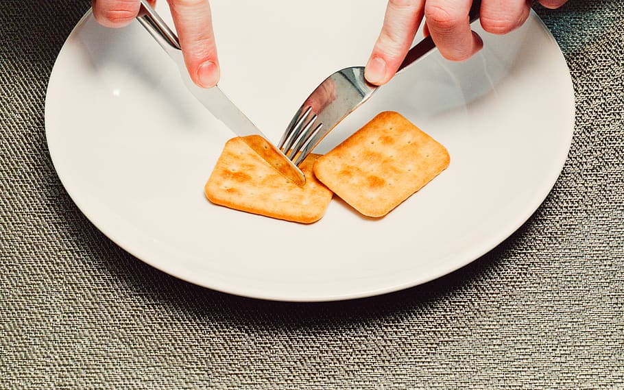 crackers, snack, food, fork, knife, plate, cutting, human hand, human body part, food and drink