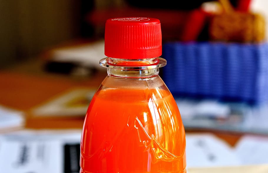 drink, bottle, orange, plastic bottle, thirst, refreshment, red, container, food and drink, focus on foreground